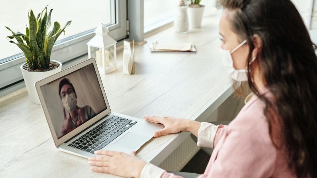 Lady with a mask having a video call with a man in a mask