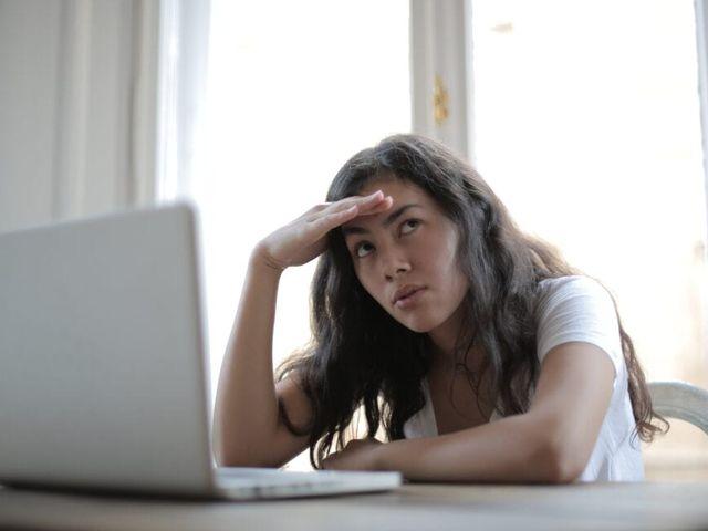 a woman stressfully looking upwards with her hand rested on her head